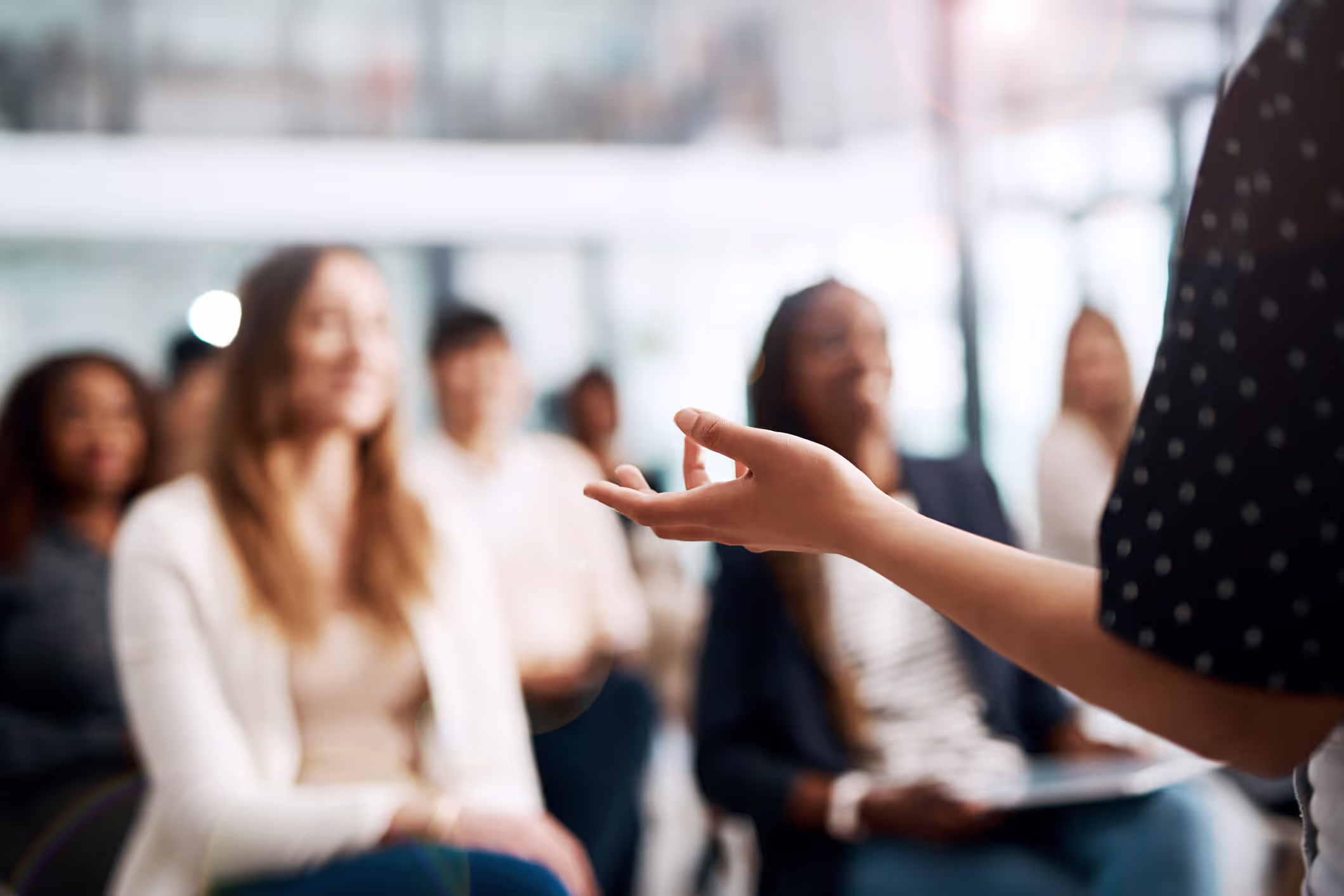 A group of people being talked to by a person in a black shirt