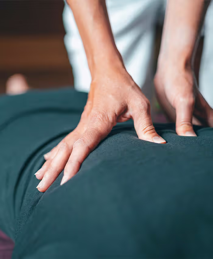 a person in a green shirt receiving a massage on their back